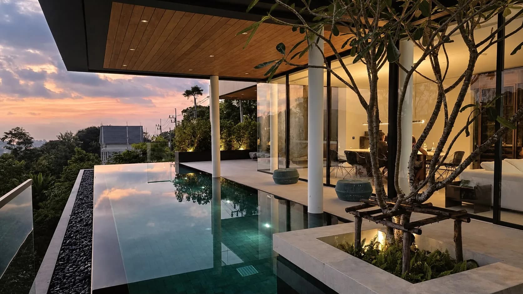 Perch House, infinity pool at dusk with the lit dining room behind the glass